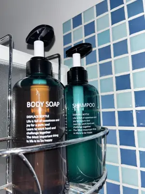 two bottles of soap and shampoo on a rack in a bathroom at Azzurra in Terrasini