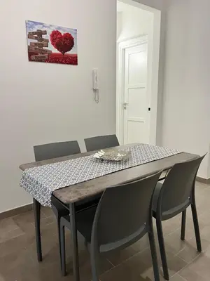 a dining room table and chairs in a room at Azzurra in Terrasini