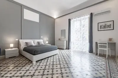 a bedroom with a bed and a large window at GuestHost - La Dimora dei Mille - Roomy Apartment with Terrace in Palermo
