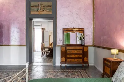 a room with a mirror and a dresser and a table at GuestHost - La Dimora dei Mille - Roomy Apartment with Terrace in Palermo