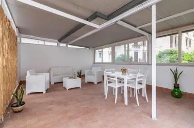 a room with a white table and chairs and windows at GuestHost - La Dimora dei Mille - Roomy Apartment with Terrace in Palermo