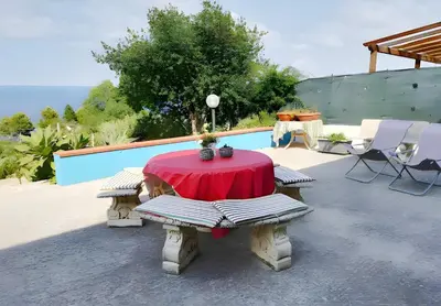 a table and two benches with a red table and chairs at Casa delle Stelle in Scopello