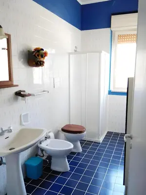 a blue and white bathroom with a toilet and a sink at Casa delle Stelle in Scopello