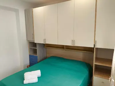 a room with a bed with white cabinets and towels at Home For You in Carini