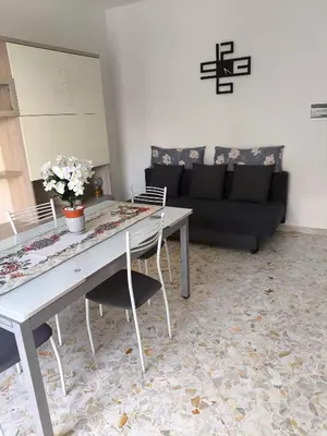 a living room with a table and a couch at Home For You in Carini