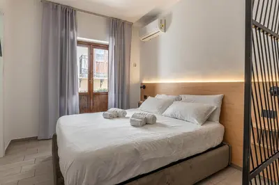 a bedroom with a bed with two towels on it at Naos Home - Alle Spalle del Teatro Massimo in Palermo