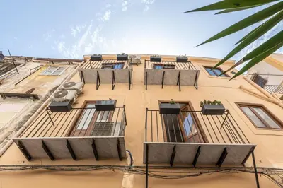 a tall yellow building with windows and balconies at Naos Home - Alle Spalle del Teatro Massimo in Palermo