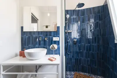 a bathroom with a blue tiled shower and a sink at Villa Makar Seaview in Macari