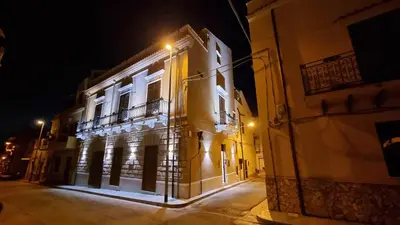 a building with a balcony on a street at night at LE TRE NINFE Cinisi in Cinisi