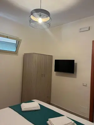 a bedroom with a bed and a flat screen tv at La casa di Gabri in Palermo