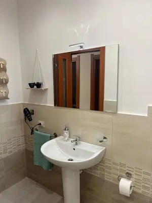 a bathroom with a white sink and a mirror at La casa di Gabri in Palermo