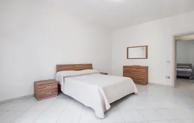 a white bedroom with a bed and two night stands at Lovely Apartment In Casteldaccia in Casteldaccia