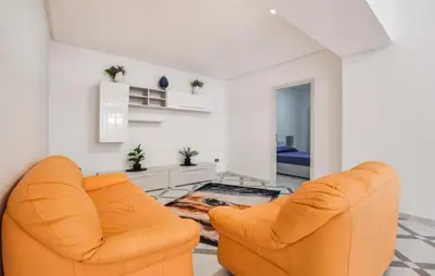two orange chairs in a white living room at Lovely Apartment In Casteldaccia in Casteldaccia