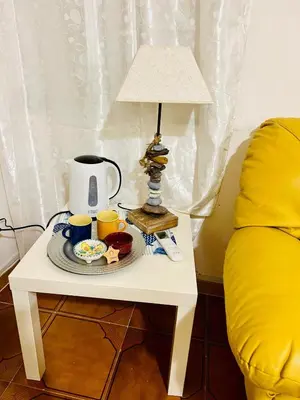 a table with a lamp and a plate of food on it at Le Case di Ciccine' in Bagheria