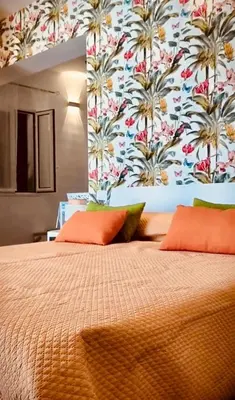 a bedroom with a large bed with a floral wallpaper at Le Case di Ciccine' in Bagheria