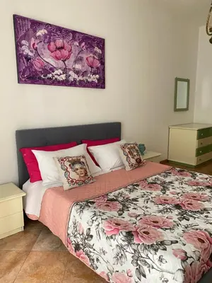 a bedroom with a large bed with pink and white pillows at La Casetta sul Corso in Palermo