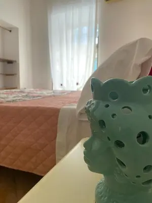 a green vase sitting on a table in a bedroom at La Casetta sul Corso in Palermo