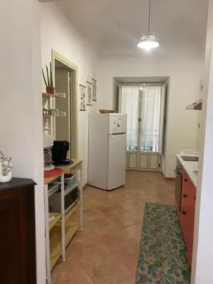 a kitchen with a white refrigerator in a room at La Casetta sul Corso in Palermo