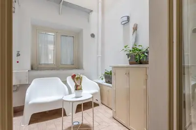 a white room with a table and a chair and a table and a mirror at MetaM Apartment in the City Center by Wonderful Italy in Palermo