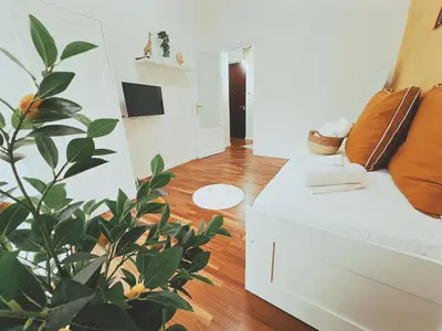 a living room with a white couch and a plant at Casa Vacanze Imera House in Palermo