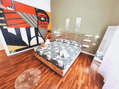 a bedroom with a bed and a painting on the wall at Casa Vacanze Imera House in Palermo