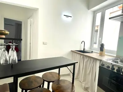a kitchen with three stools sitting under a counter at City SEA DOWNTOWN in Palermo