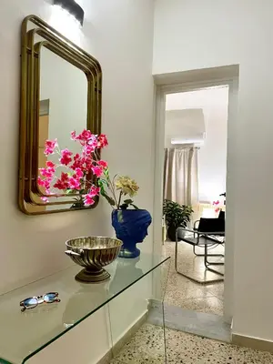 a mirror and a vase with flowers on a glass table at City SEA DOWNTOWN in Palermo