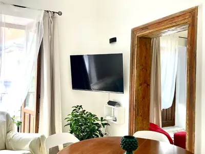 a living room with a table and a tv on the wall at City SEA DOWNTOWN in Palermo