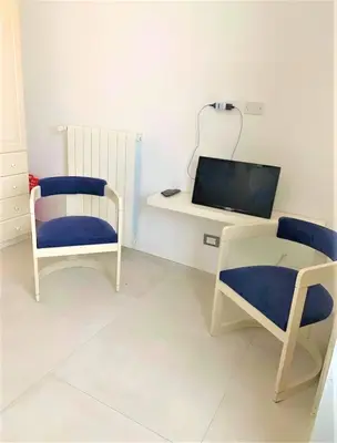 a room with two chairs and a table and a mirror at Casa Giulù- in Palermo