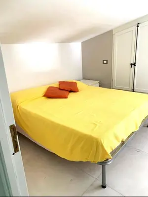 a bed with two red pillows on it in a room at Casa Giulù- in Palermo