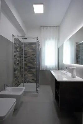 a white bathroom with two sinks and a shower at villa grecale in Castellammare del Golfo