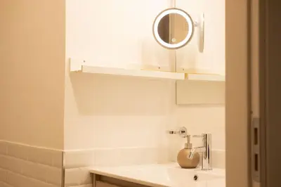 a white bathroom with a sink and a mirror at Il Sipario Luxury Apartments in Palermo