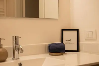 a bathroom sink with a mirror and a towel at Il Sipario Luxury Apartments in Palermo