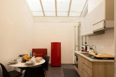 a kitchen with a table and a red refrigerator at Il Sipario Luxury Apartments in Palermo