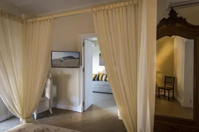 a bedroom with a bed and a mirror and curtains at Pane Amore e Marmellata in Palermo