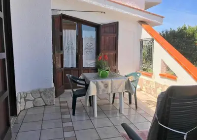 a table and chairs on the patio of a house at La villa di Turi in Castellammare del Golfo