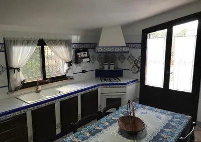 a kitchen with a table and a sink and a counter top at La villa di Turi in Castellammare del Golfo