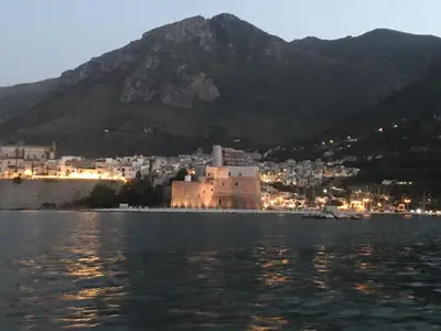 a town on the water with a mountain in the background at La villa di Turi in Castellammare del Golfo