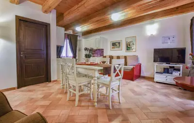 a kitchen with a table and chairs and a living room at Cozy Home In Partinico With Wifi in Partinico