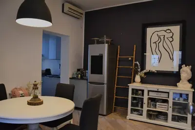 a living room with a table and a refrigerator at Little Loft 39 in Palermo