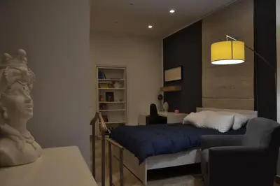 a bedroom with a bed and a couch and a lamp at Little Loft 39 in Palermo