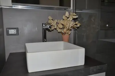 a white sink in a bathroom with a vase of flowers at Little Loft 39 in Palermo