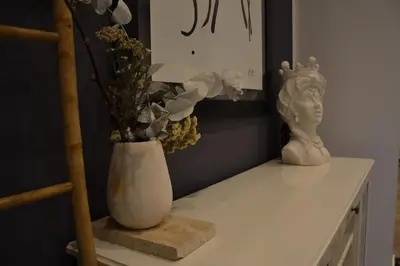 a table with a vase and a statue on it at Little Loft 39 in Palermo