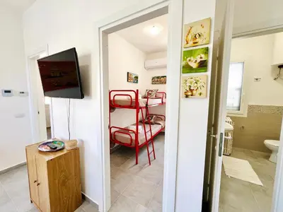 a living room with a red chair and a television at Stella Marina in Carini