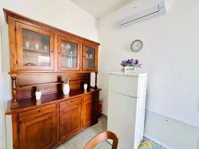 a kitchen with a wooden cabinet and a refrigerator at Stella Marina in Carini