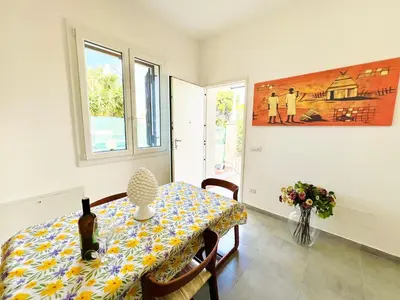 a dining room table with a bottle of wine on it at Stella Marina in Carini