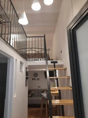 a spiral staircase in a room with a couch at Sweet home Palermo in Palermo