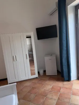 a room with a mirror and a tv on the wall at Central Station in Palermo