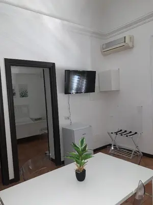 a living room with a white table and a mirror at Central Station in Palermo