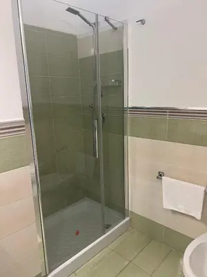 a shower with a glass door in a bathroom at Central Station in Palermo